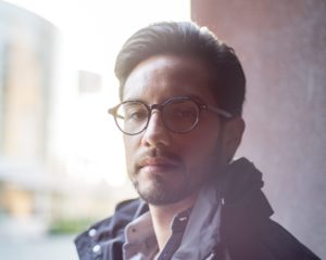 hazy portrait session of male model with glasses looking at camera