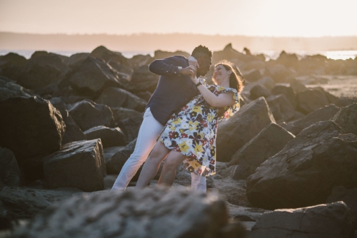 engagement session coronado island sunset san diego california white girl yellow blue red dress african american interracial couple rocks dancing